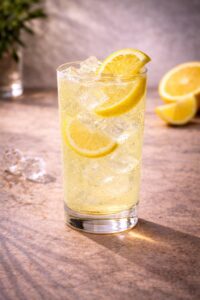 Leckerer Cocktail am Tresen mit Zitrone, Limette, Minze als Verzierung - Longdrink